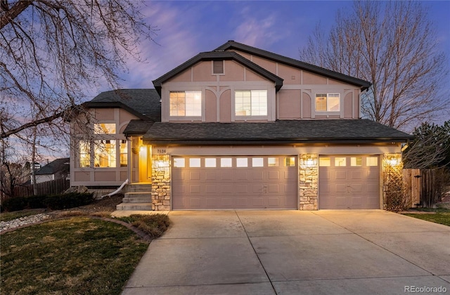 7636 S Allison Ct, Littleton, CO 80128 - view of front of home featuring an attached garage, driveway, stone siding, a shingled roof, and stucco siding