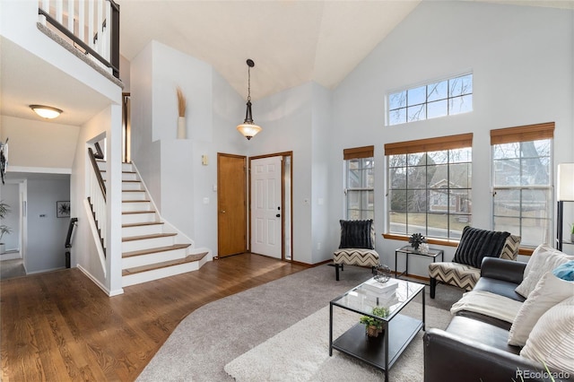 7636 S Allison Ct, Littleton, CO 80128 - living room featuring high vaulted ceiling, stairs, and wood finished floors