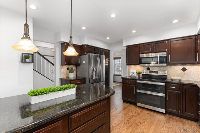 7636 S Allison Ct, Littleton, CO 80128 - kitchen featuring appliances with stainless steel finishes, light wood-style flooring, pendant lighting, dark brown cabinetry, and backsplash