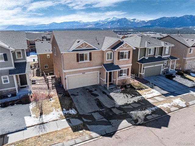 view of front facade with a garage, concrete driveway, a residential view, and stucco siding