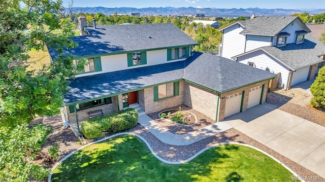 view of front of property featuring a front yard, a garage, and a mountain view