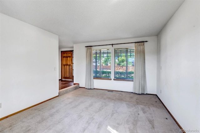 carpeted spare room with a textured ceiling