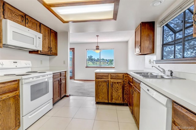 kitchen featuring light tile patterned floors, decorative light fixtures, sink, and white appliances