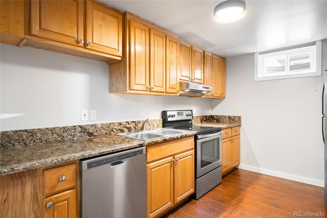 4300 Osage St, Denver, CO 80211 - kitchen featuring stainless steel appliances, under cabinet range hood, dark wood-style flooring, and brown cabinetry