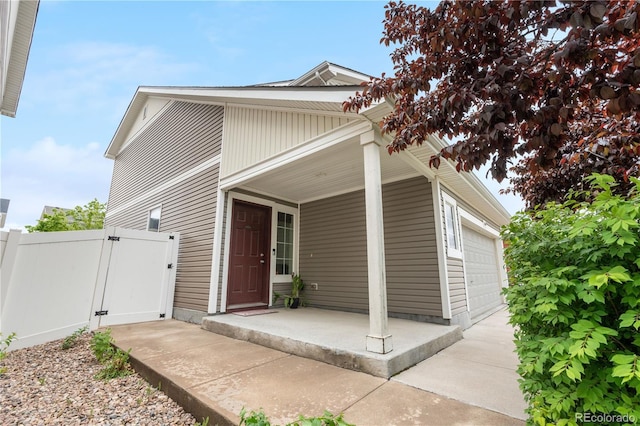 5536 Kirk St, Denver, CO 80249 - view of front of home with a gate, a garage, covered porch, and concrete driveway