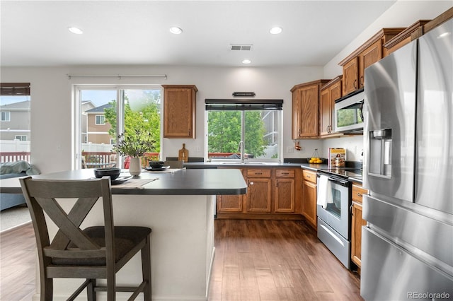 5536 Kirk St, Denver, CO 80249 - kitchen featuring stainless steel appliances, wood finished floors, a sink, recessed lighting, and dark countertops