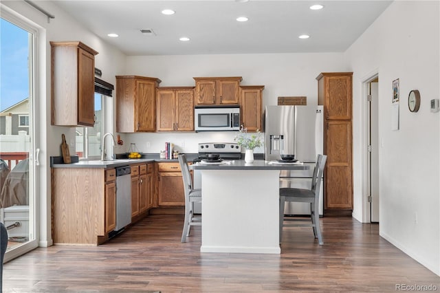 5536 Kirk St, Denver, CO 80249 - kitchen with appliances with stainless steel finishes, a kitchen island, dark wood finished floors, a breakfast bar, and recessed lighting