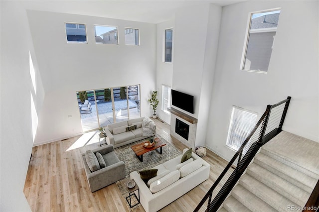 living room with a towering ceiling and light hardwood / wood-style flooring