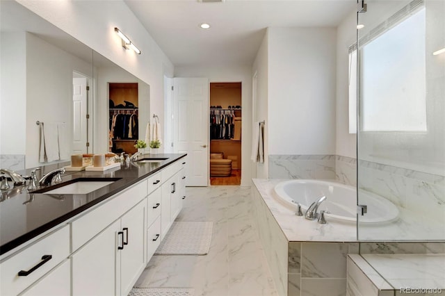 bathroom featuring vanity and tiled bath