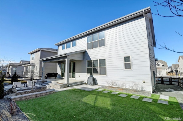 back of house featuring a patio area and a lawn