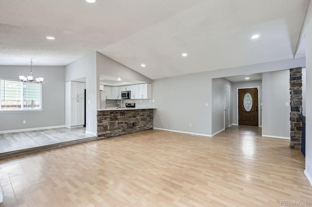 10723 Cherry Ct, Thornton, CO 80233 - unfurnished living room featuring light wood-type flooring, a chandelier, lofted ceiling, baseboards, and recessed lighting