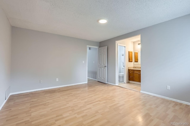 10723 Cherry Ct, Thornton, CO 80233 - unfurnished bedroom with light wood-style flooring, baseboards, a textured ceiling, and connected bathroom
