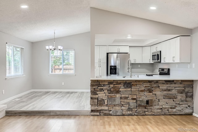 10723 Cherry Ct, Thornton, CO 80233 - kitchen featuring lofted ceiling, appliances with stainless steel finishes, light wood-style flooring, white cabinetry, and a textured ceiling