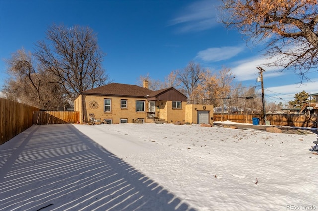 view of snow covered rear of property