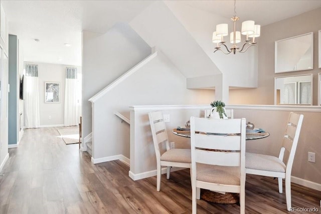 dining room with a chandelier, baseboards, and wood finished floors