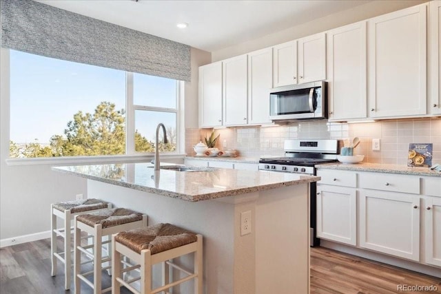 kitchen featuring appliances with stainless steel finishes, plenty of natural light, a breakfast bar area, and a sink