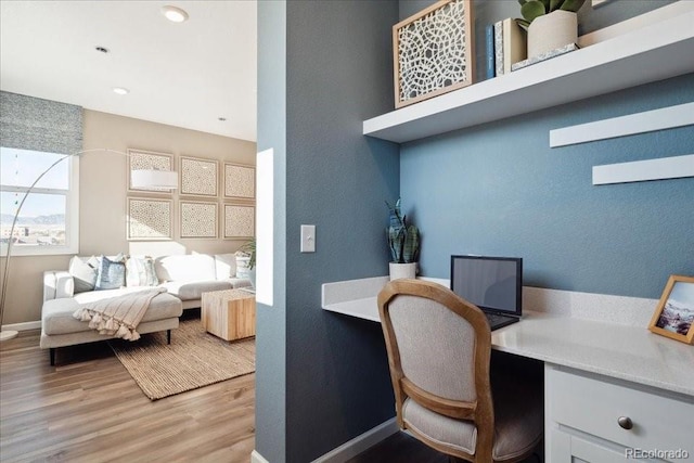 office with built in desk, recessed lighting, baseboards, and wood finished floors