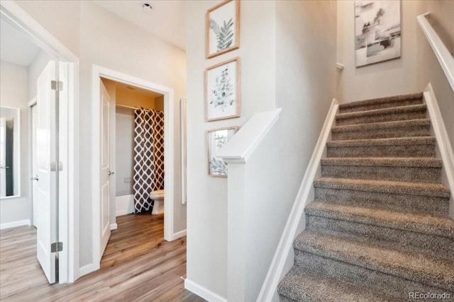 stairs with wood finished floors and baseboards