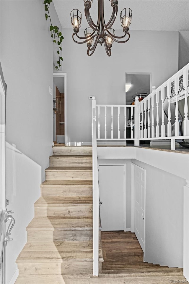 staircase featuring a notable chandelier and hardwood / wood-style floors