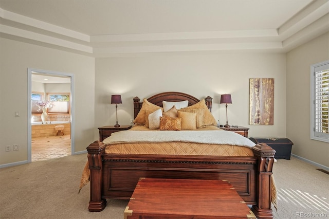 bedroom featuring light carpet, ensuite bath, and baseboards