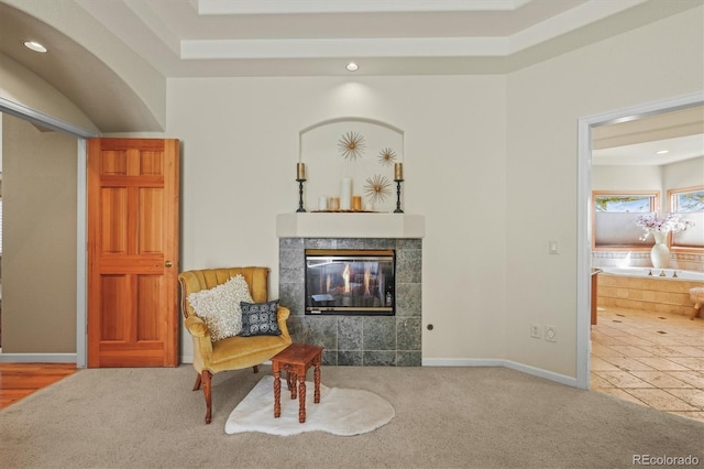 living area with carpet, baseboards, a tiled fireplace, and recessed lighting