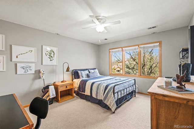 bedroom featuring light colored carpet, ceiling fan, visible vents, and baseboards