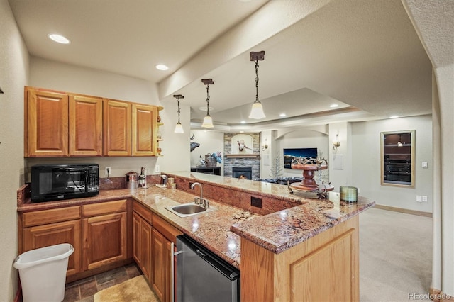 kitchen with a tray ceiling, open floor plan, a sink, black microwave, and a peninsula