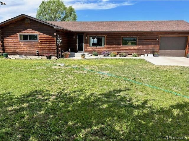 cabin featuring a front lawn and a garage