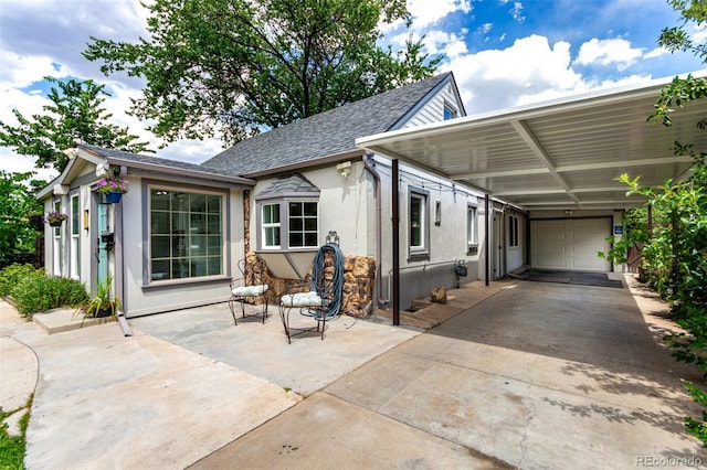 1946 Xenia St, Denver, CO 80220 - view of front of home featuring roof with shingles, a garage, an attached carport, concrete driveway, and stucco siding