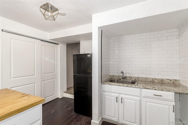1946 Xenia St, Denver, CO 80220 - kitchen featuring freestanding refrigerator, dark wood-style floors, and white cabinets