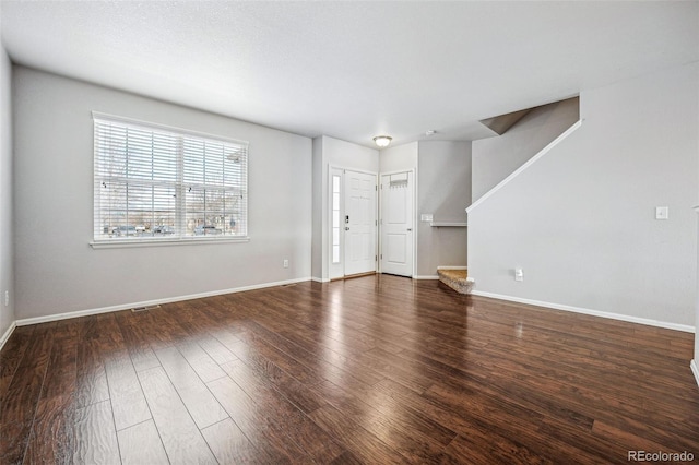 unfurnished living room with dark wood-type flooring