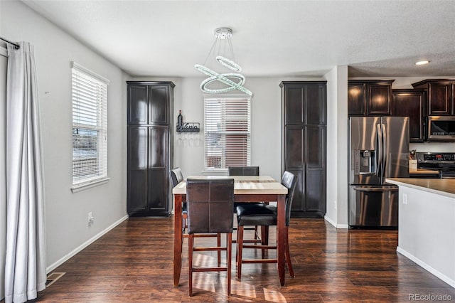 dining room featuring a notable chandelier, dark hardwood / wood-style floors, and a textured ceiling