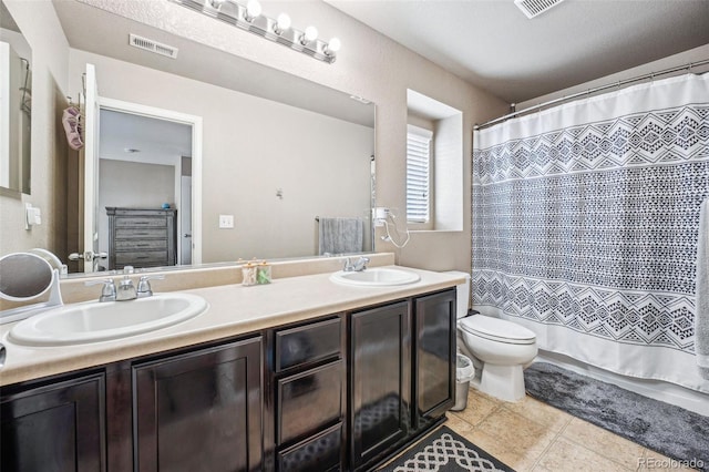 bathroom featuring curtained shower, tile patterned flooring, vanity, and toilet