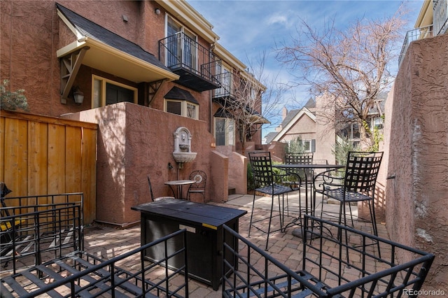 view of patio featuring outdoor dining area and fence