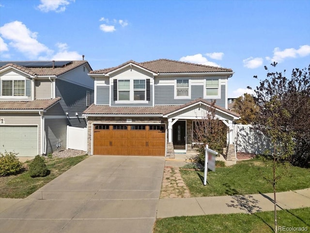5555 Perth Ct, Denver, CO 80249 - view of front facade with a garage, concrete driveway, a tiled roof, and fence