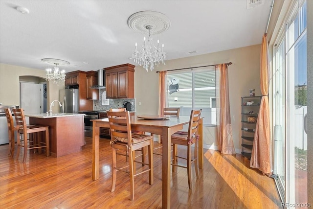5555 Perth Ct, Denver, CO 80249 - dining space featuring light wood-style flooring, baseboards, and a chandelier