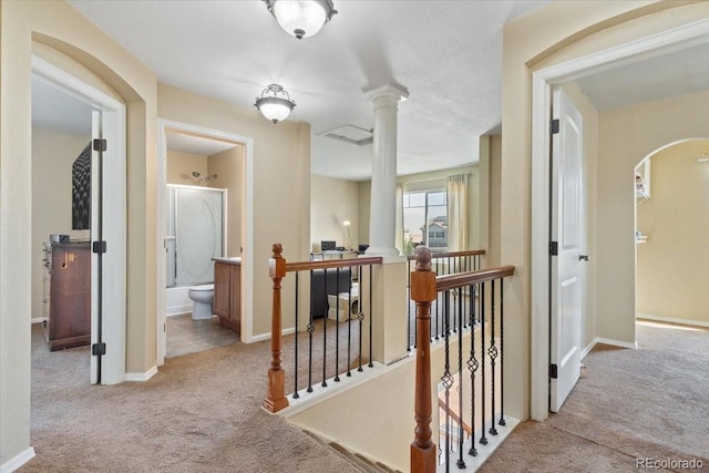 hallway featuring light carpet and decorative columns