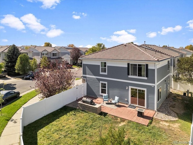 5555 Perth Ct, Denver, CO 80249 - rear view of house with a patio area, a lawn, a tiled roof, a fenced backyard, and a residential view