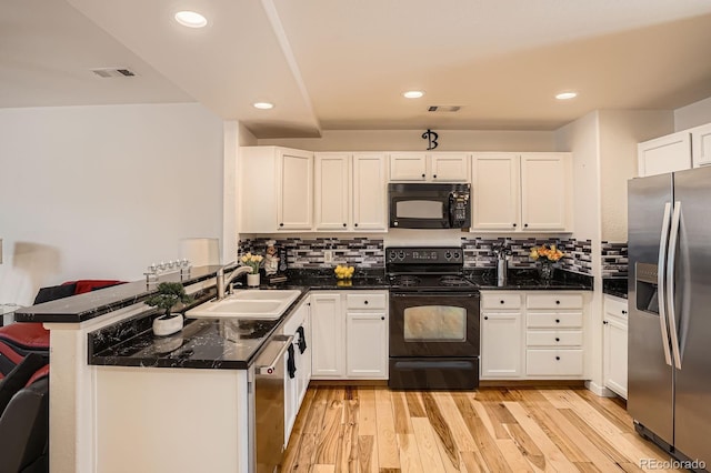 8751 Pearl St Unit J3, Thornton, CO 80229 - kitchen featuring black appliances, white cabinets, a peninsula, tasteful backsplash, and recessed lighting