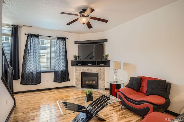 8751 Pearl St Unit J3, Thornton, CO 80229 - living room with wood finished floors, ceiling fan, a high end fireplace, and a textured ceiling