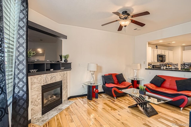 8751 Pearl St Unit J3, Thornton, CO 80229 - living room featuring ceiling fan, light wood-style floors, and a fireplace