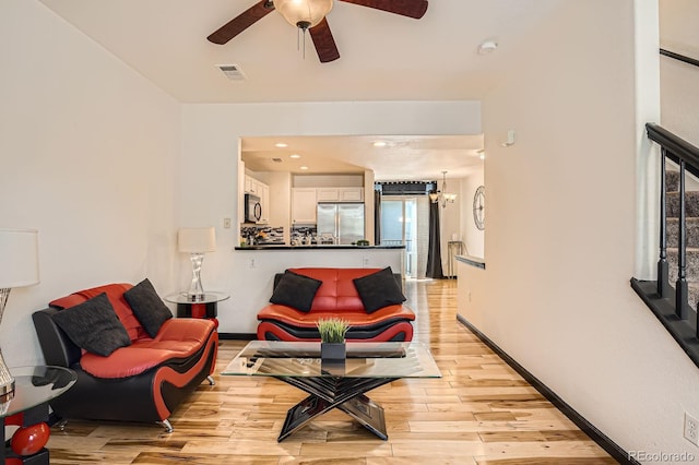 8751 Pearl St Unit J3, Thornton, CO 80229 - living room featuring light wood-type flooring, ceiling fan, and a chandelier
