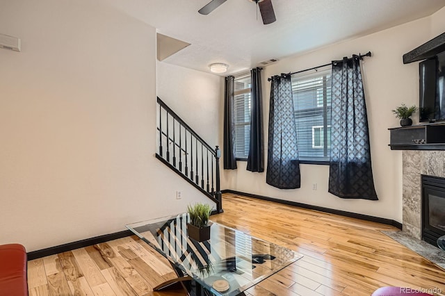 8751 Pearl St Unit J3, Thornton, CO 80229 - living room featuring stairway, a premium fireplace, hardwood / wood-style floors, and ceiling fan