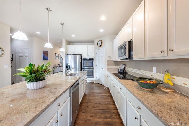 kitchen with light stone countertops, stainless steel appliances, sink, pendant lighting, and white cabinets