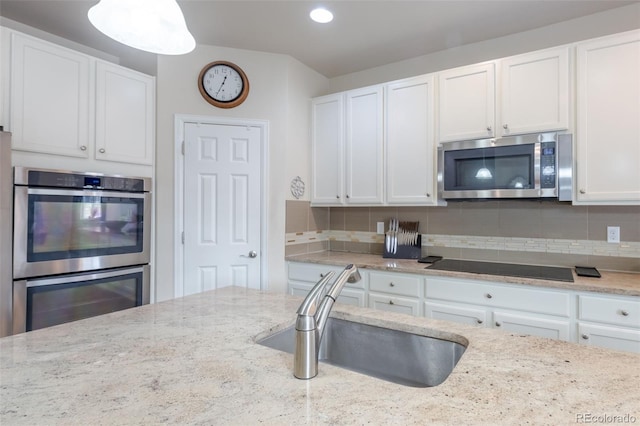 kitchen featuring backsplash, white cabinetry, sink, and appliances with stainless steel finishes