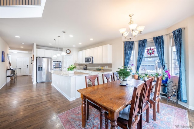 dining space featuring a chandelier, dark wood-type flooring, and sink