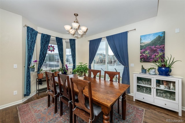 dining room with dark wood-type flooring and a notable chandelier