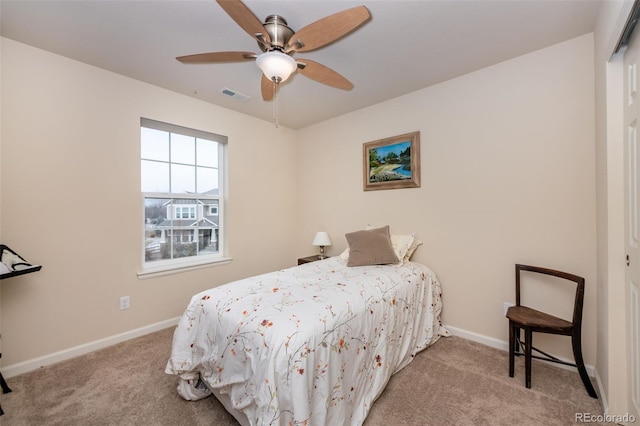 carpeted bedroom featuring ceiling fan and a closet