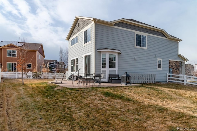 rear view of property featuring a lawn and a patio