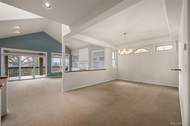 carpeted empty room featuring built in shelves, vaulted ceiling, and a notable chandelier